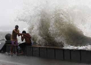 A couple plays in the waves at Manila Bay caused by Typhoon Fengshen as it rolls over Manila June 22, 2008. (Xinhua/Reuters Photo)