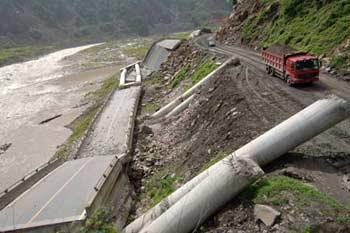 An engineering vehicle passes the temporary line of the No. 213 national highway connecting Dujiangyan City and Wenchuan County in southwest China's Sichuan Province, June 17, 2008. Some 43.3 kilometers of the national and provincial highways still remain to be repaired after the Wenchuan earthquake.(Xinhua Photo)