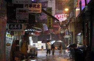 People holding umbrellas walk in rain in south China's Hong Kong on June 25, 2008. Hong Kong was affected by heavy rain as the Typhoon Fengshen headed towards the southern Chinese city. The Hong Kong Observatory issued the No. 8 Northeast Gale or Storm Signal on Tuesday and red warning on Wednesday.(Xinhua Photo)