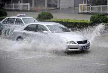 Cars drive in flooded streets in Shenzhen City, south China's Guangdong Province, on June 25, 2008. Tropical storm Fengshen hit the southeast coast of China early on Wednesday, bringing about heavy rains and strong winds. The storm made the landfall in the coastal area of Shenzhen at 5:30 a.m. with winds of up to 83 kilometers per hour, according to the provincial meteorological station.(Xinhua Photo)
