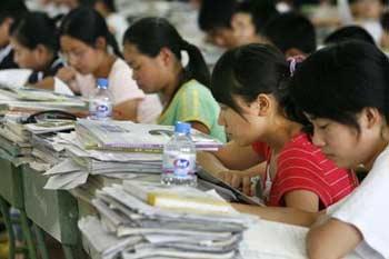 Middle school students do a review for their college entrance examination in a temporary classroom in the earthquake-hit Anxian county, Sichuan province June 28, 2008. Some 1,800 students are attending review classes in a warehouse-converted into a giant classroom to prepare for the annual national college entrance examination, or "gaokao". The examination for the 62 quake-ravaged counties and districts in Sichuan and Gansu provinces was postponed until July 3 to 5, the Ministry of Education said.(Source: China Daily)