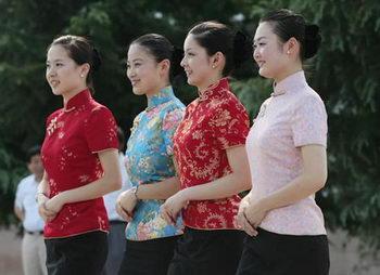 Four flight attendants from China Eastern Airlines model new colorful uniforms, which were unveiled Tuesday. The uniform, made from a traditional southern Chinese silk called yunjin, cost about 10,000 yuan each. This traditional uniform will be worn for charter flights from the Chinese mainland to Taipei, which begin on July 4.[Xinhua]