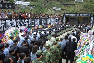 The memorial ceremony for three policemen is held at a revolutionary martyr mausoleum in Lixian County, Aba Prefecture, southwest China's Sichuan Province, July 3, 2008. Thousands of people attended the memorial ceremony of three martyrs in the quake. Three policemen, called Chen Jian, Zhao Xiang and Tang Chao, were killed when their aircraft crashed on a quake relief mission on May 31. The Mi-171 helicopter was carrying injured civilians when it crashed in the mountains in turbulence on a return trip from Lixian County to Chengdu in quake-hit Sichuan Province.(Xinhua/Jin Liangkuai)