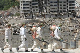 Soldiers walk to disinfect the debris of houses in the seat of Beichuan Qiang Autonomous County, southwest China's Sichuan Province, July 5, 2008. The Beichuan county seat was destroyed in the May 12, 8-magnitude quake. Soldiers of an anti-chemical regiment of the Chinese People's Liberation Army have been disinfecting Beichuan since May 18 to prevent epidemics. (Xinhua Photo)