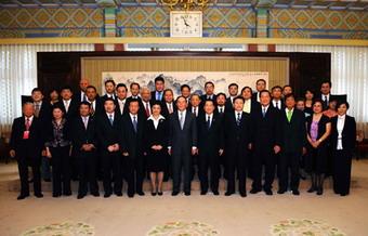 Chinese Vice Premier Wang Qishan (front,C) poses for a group photo with the overseas Chinese entrepreneurs who are going to pay a visit to southwest China's Sichuan Province in Beijing, capital of China. July 7, 2008. (Xinhua/Li Tao)