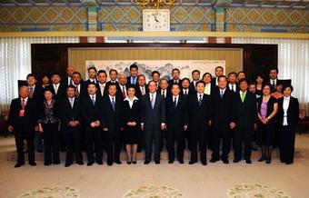 Chinese Vice Premier Wang Qishan (front,C) poses for a group photo with the overseas Chinese entrepreneurs who are going to pay a visit to southwest China's Sichuan Province in Beijing, capital of China. July 7, 2008. (Xinhua/Li Tao)