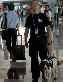 A policeman patrols with a police dog at terminal 3 of the Beijing Capital International Airport in Beijing, China, July 20, 2008.(Xinhua Photo)
