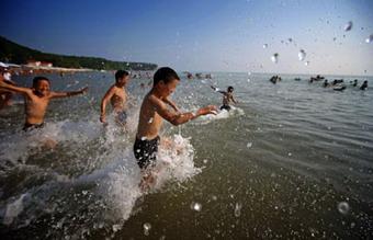 Students from southwest China's Sichuan Province play in the sea in Tuapse, a city on Russia's Black Sea coast, July 21, 2008. A group of 184 students from China's earthquake-hit province of Sichuan arrived at a summer camp in Tuapse on July 19 for a three-week rehabilitation visit.(Xinhua Photo)