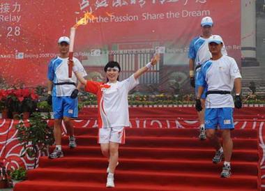 Torchbearer Li Ruiying (2nd L) runs with the torch at the launching ceremony of the Beijing 2008 Olympic Games torch relay in Anyang, central China's Henan Province, July 28, 2008.(Xinhua/Zhu Xiang)