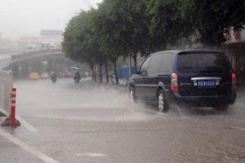 Vehicles splash through a flooded street in Fuzhou City, capital of southeast China's Fujian Province, July 28, 2008. Typhoon Fung Wong, which was lashing Taiwan on Monday morning, continued to strengthen as it headed toward the southeastern coast of mainland China, according to the observatory of Fujian Province. (Xinhua/Jiang Kehong)