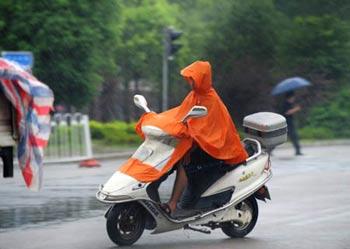 A motorcyclist rides against the rain in Fuzhou City, capital of southeast China's Fujian Province, July 28, 2008. (Xinhua/Jiang Kehong)