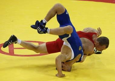 Mavlet Batirov of Russia (in blue) fights Vasyl Fedoryshyn of Ukraine during their 60kg men's freestyle wrestling final match at the Beijing 2008 Olympic Games August 19, 2008. [Agencies]