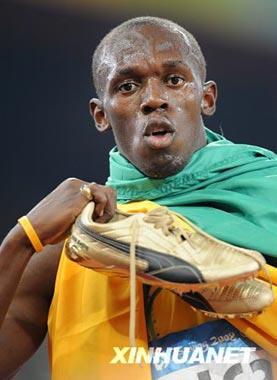 Usain Bolt of Jamaica shows his running shoes to spectators after the men's 200m final at the National Stadium, also known as the Bird's Nest, during Beijing 2008 Olympic Games in Beijing, China, Aug. 20, 2008. Usain Bolt of Jamaica won the title with 19.30 seconds and set a new world record. (Xinhua/Guo Dayue)