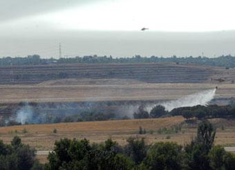 Fire helicopters try to put out fire as a Spanish plane catches fire at Madrid's Barajas airport, Aug. 20, 2008. (Xinhua Photo)