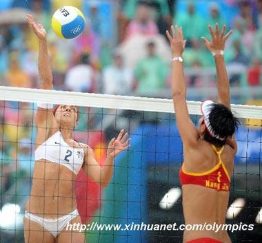 Misty May-Treanor (L) of US spikes during the women's gold medal match against Wang Jie and Tian Jia of China at the Beijing 2008 Olympic Games beach volleyball event in Beijing, China, Aug. 21, 2008. Kerri Walsh and Misty May-Treanor of US won the match 2-0 and got the gold medal. (Xinhua/Sadat)