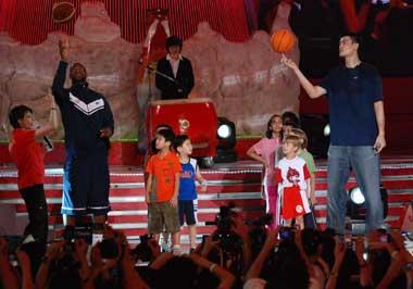 NBA stars LeBron James (2nd L) and Yao Ming (R) play a basketball game with kids during a promotion show for Olympics in Beijing on August 21, 2008. [Xinhua]