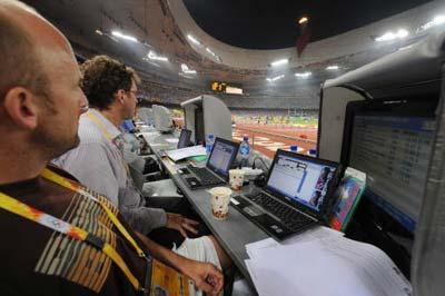 AFP reporters work in the press tribune as they watch the women's 110 metre hurdle heats during the track and field events inside the National Stadium during the 2008 Beijing Olympic Games in Beijing on August 18, 2008.