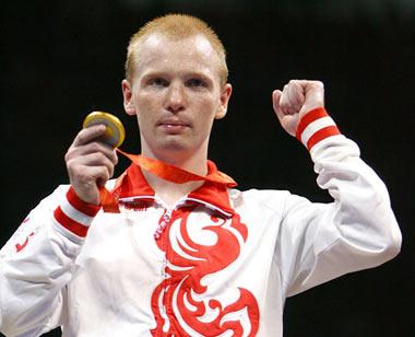 Alexey Tishchenko holds up the gold medal. (Photo credit: Al Bello/Getty Images)