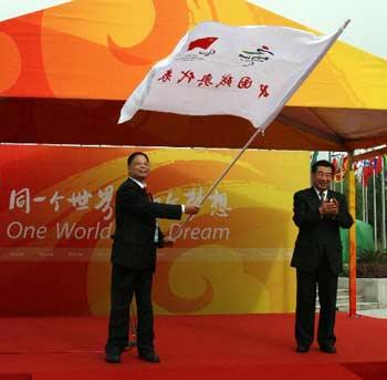 Chinese Vice Premier Hui Liangyu (R) hands over the flag of China's Paralympic delegation to Wang Xinxian, the head of the delegation, in the Paralympic Village in Beijing on Saturday, August 30, 2008. [Photo: Xinhua]