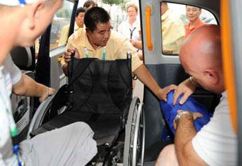 A volunteer helps move the wheelchair of French athlete Nicolas Peifer into a barrier-free taxi in front of the Main Press Center in Beijing Sept. 4, 2008. Many barrier-free facilities were installed in buses, taxis and subway stations, making it more convenient for disable people to get on and off.(Xinhua Photo)