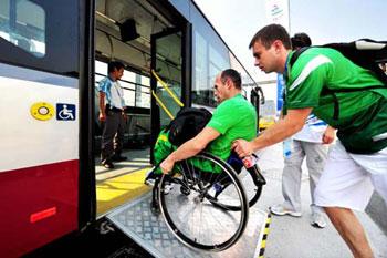 A Paralympic athlete rolls his wheelchair up a ramp with the help of a team staff member to get onto a bus in this picture taken on September 3, 2008.