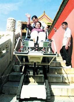 Xie Xiuying, one of a group of disabled people from Dongcheng district, uses a wheelchair hoist to navigate a flight of stairs at the Palace Museum yesterday.