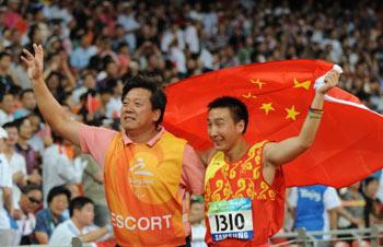Zhu Pengkai (R) of China is escorted by his guide as he celebrates after winning the final of the men's javelin F11-12 classification event at the 2008 Beijing Paralympic Games in Beijing on September 10, 2008.