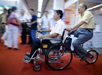 People try a multifunctional wheelchair during a visit to an exhibition for the rehabilitative and assistive facilities held in Beijing September 11, 2008. The three-day expo, started on Thursday, will display more than 1,000 types of products for the physically challenged like hearing aids, special vehicles for the disabled, prosthetic limbs and diapers for the paralyzed.(Xinhua/Liu Jie)