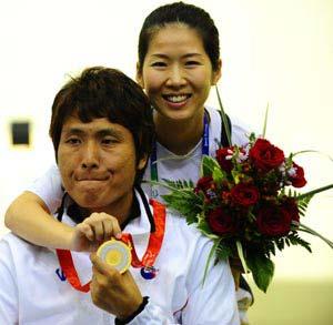 South Korean athlete Lee Ji-Seok poses for photos with his wife Park Kyoung-Sun after winnning in the Mixed R4-10m Air Rifle Standing SH2 final with a total of 704.3 in Beijing Paralympic Shooting event at the Beijing Shooting Range Hall Sept. 11, 2008. This is Lee's second gold medals in the Beijing 2008 Paralympic Games. Lee was seriously injured in a traffic accident in 2001. It was Park, a nurse then, who took good care of him during his rehabilitation and later encouraged him to train for shooting.(Xinhua/Ren Yong)