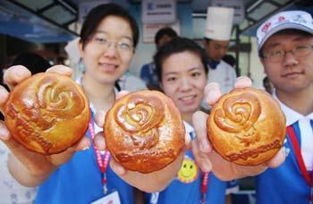 Volunteers for the Beijing Paralympic Games show the mooncakes they make at a Paralympics city volunteer stand near the Xidan Shopping Center in downtown Beijing, capital of China, Sept. 11, 2008. Some volunteers made mooncakes to share with other working fellows as the Mid-Autumn Festival, a traditional Chinese holiday for family reunion and having mooncakes together, falls on Sept. 14 this year. (Xinhua/Jiao Wei) 