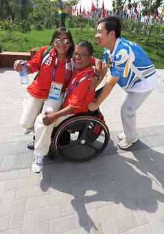 A volunteer helps members of the Mexican delegation at the Paralympic Village in Beijing Sept. 4, 2008. Some 44,000 volunteers are serving for the ongoing Beijing 2008 Paralympic Games and 90 percent of them have worked for the Olympic Games last month. [Xinhua]