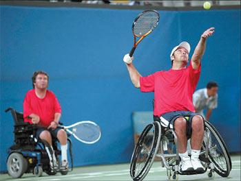 David Wagner (right) serves as partner Nick Taylor looks on during the final of quad doubles open gold medal match against Boaz Kramer and Shraga Weinberg of Israel. [China Daily]