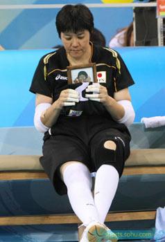 A Japanese athlete holds up a photo of her late teammate when competing in sitting volleyball match during the Beijing Paralympic Games, September 13, 2008. The 21-year-old girl, former member of Japanese sitting volleyball team, had a dream of taking part in the Beijing Paralympics but passed away on August 12, 2008.[Sohu.com]