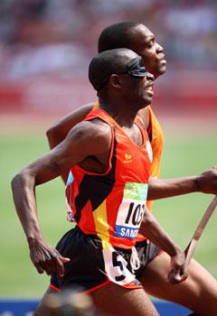 Angola's Jose Armando (L) and his guide compete during the first round match of men's 400m T11 event at the National Stadium, also known as the Bird's Nest, during the Beijing 2008 Paralympic Games in Beijing, Sept. 14, 2008. Armando was qualified for the semifinal with a time of 51.52 seconds. (Xinhua/Zhang Yanhui)