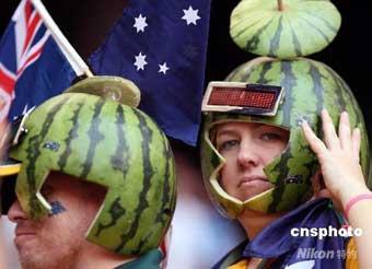 Two Australian spectators with watermelon helmet on the head watch athletic event at Beijing 2008 Paralympic Games on Sept. 14, 2008.(Photo: Chinanews.com)