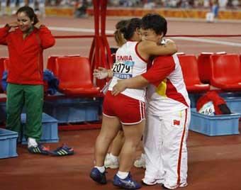 Tunisia's Raoua Tlili and China's Menggen Jimisu (R) congratulate each other after women's shot put F40 final at the National Stadium，also known as the Bird's Nest，during the Beijing 2008 Paralympic Games in Beijing, Sept. 15, 2008. Tlili won the gold medal with 8.95 meters. Menggen Jimisu won the silver medal.(Xinhua Photo)