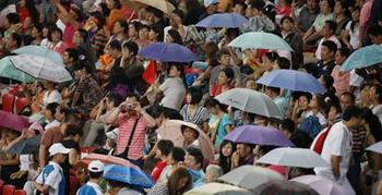 Audience watch the athletics match in the heavey rain at the National Stadium，also known as the Bird's Nest，during the Beijing 2008 Paralympic Games in Beijing, Sept. 16, 2008. (Xinhua/Liao Yujie)