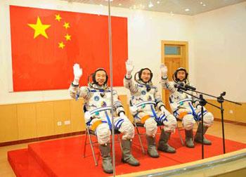 Chinese taikonauts (R-L) Liu Boming, Zhai Zhigang and Jing Haipeng wave to photographers as they wait to set out at the taikonauts' apartment in the Jiuquan Satellite Launch Center in northwest China's Gansu Province, Sept. 25, 2008.(Xinhua/Li Tao)