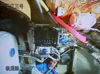 The video grab taken on Sept. 26, 2008 at the Beijing Space Command and Control Center in Beijing, China, shows Chinese astronaut Liu Boming unpacking and assembling the indigenous Feitian extra-vehicular activity (EVA) suit in Shenzhou-7. Astronauts aboard the Shenzhou-7 spacecraft, China's third manned spaceship, began to assemble the suit and test its obturation and functions at 10:20 a.m. Friday in preparation for the first spacewalk.  (Xinhua/