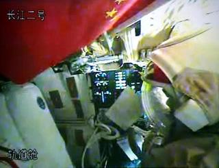 Chinese taikonauts Zhai Zhigang and Liu Boming try their space suits in the orbit module of the Shenzhou-7 spacecraft, in this video grab taken on Sept. 26, 2008. The Shenzhou-7 spacecraft, which blasted off at 9:10 p.m. Thursday at the Jiuquan Satellite Launch Center in northwest China's Gansu Province, has functioned well as planned. (Xinhua/Zha Chunming)