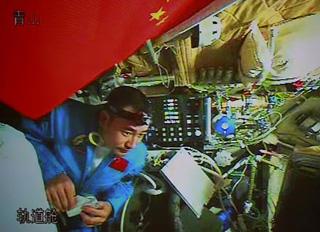 Chinese taikonaut Zhai Zhigang tries a bite on his food in the orbit module of the Shenzhou-7 spacecraft, in this video grab taken on Sept. 26, 2008. The Shenzhou-7 spacecraft, which blasted off at 9:10 p.m. Thursday at the Jiuquan Satellite Launch Center in northwest China's Gansu Province, has functioned well as planned. (Xinhua/Zha Chunming)
