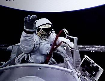 The video grab taken at the Beijing Space Command and Control Center on Sept. 27, 2008 shows Chinese taikonaut Zhai Zhigang waving while walking out of the orbit module of the Shenzhou-7 spacecraft.(Xinhua/Chen Jianli)