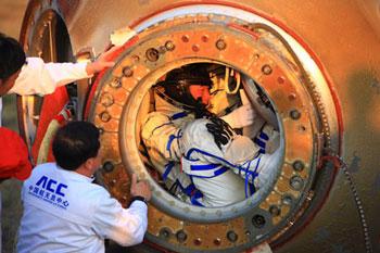 One of the three Chinese taikonauts (R) is ready to get out of Shenzhou-7 re-entry module after their safe landing in North China's Inner Mongolia Autonomous Region on Sept. 28, 2008.(Xinhua/Li Gang)