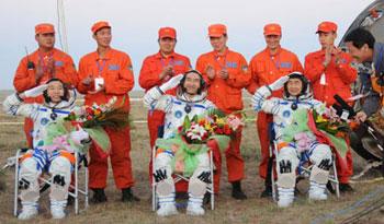 Chinese taikonauts (front) salute after they get out of Shenzhou-7 re-entry module after their safe landing in North China's Inner Mongolia Autonomous Region on Sept. 28, 2008.(Xinhua/Li Gang)