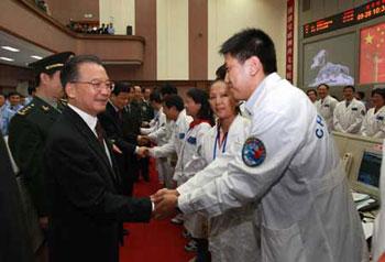 Chinese Premier Wen Jiabao (L) shakes hands with an engineer at Beijing Space Command and Control Center in Beijing, capital of China, on Sept. 28, 2008. Premier Wen Jiabao watched the return of China's Shenzhou-7 spacecraft in a live transmission in the center. (Xinhua/Pang Xinglei)