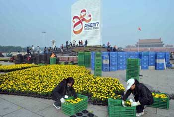 Gardeners put flowers pots in front of the logo of the 7th Asia-Europe Meeting (ASEM) summit at the Tian'anmen Square in Beijing, capital of China, on Oct. 20, 2008. China will host the 7th ASEM summit in Beijing from Oct. 24 to 25, with 43 ASEM members, the ASEAN secretary general and the president of the European Commission to be attending.(Xinhua/Yuan Man)