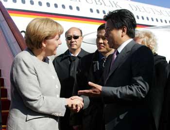 German Chancellor Angela Merkel (L) is greeted upon her arrival at the airport in Beijing, capital of China, on Oct. 23, 2008. Merkel arrived in Beijing on Thursday morning, starting her official visit to China. She would also attend the seventh Asia-Europe Meeting (ASEM) to be held on Oct. 24-25.(Xinhua/Zhai Xi) 