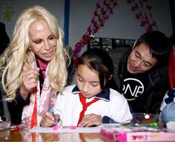 Italian designer Donatella Versace (L) and Chinese actor Jet Li watch a girl drawing at the Versace-One Foundation children center at Sanjiang, Wenchuan county, southwest China's Sichuan Province, Nov. 11, 2008. The center provides psychological consulting and therapy for children surviving the May 12 earthquake. (Xinhua Photo)
