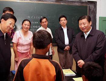 Chinese Vice President Xi Jinping (R) talks with a pupil at Man'en Jiuyi School of Man'en Village in Menghai County, southwest China's Yunnan Province, Nov. 17, 2008. Xi Jinping made an inspection in Yunnan Province on Nov. 17-20. (Xinhua/Lan Hongguang)