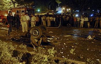 Onlookers stand at the site of a bomb blast in Mumbai November 26, 2008. At least 80 people were killed in a series of attacks apparently aimed at tourists in India's financial capital Mumbai on Wednesday night, with television channels saying Westerners were being held hostage at two five-star hotels. At least 250 people have been wounded, police said. [Agencies]